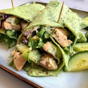 Mediterranean wrap with chicken and red bell peppers on a plate.